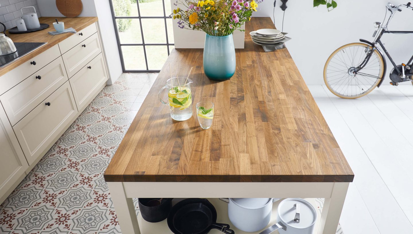 Topdown-View auf eine Holzarbeitsplatte, auf der Blumen und Limonade stehen.