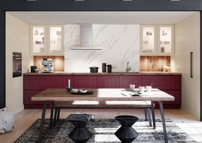 Rote Küchenzeil im Landhausstil mit großen Esstisch im Vordergrund.