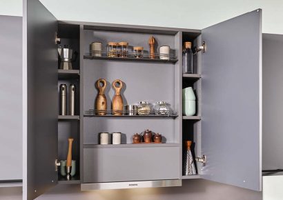 Offener Gewürzschrank über einem Kochfeld.