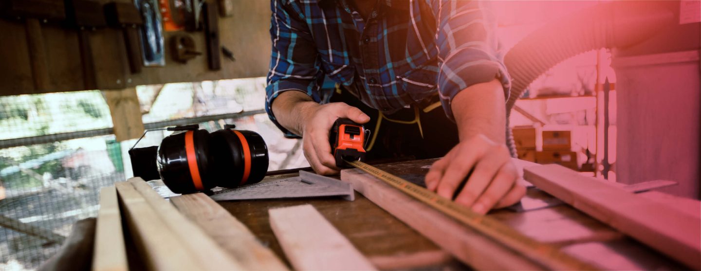 Ein Tischler misst ein Stück Holz aus – Service des Küchenstudios Helmke in Langwedel