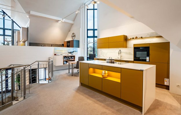 Gelbe Küchenzeile mit weißer Steinarbeitsplatte und Kochinsel.