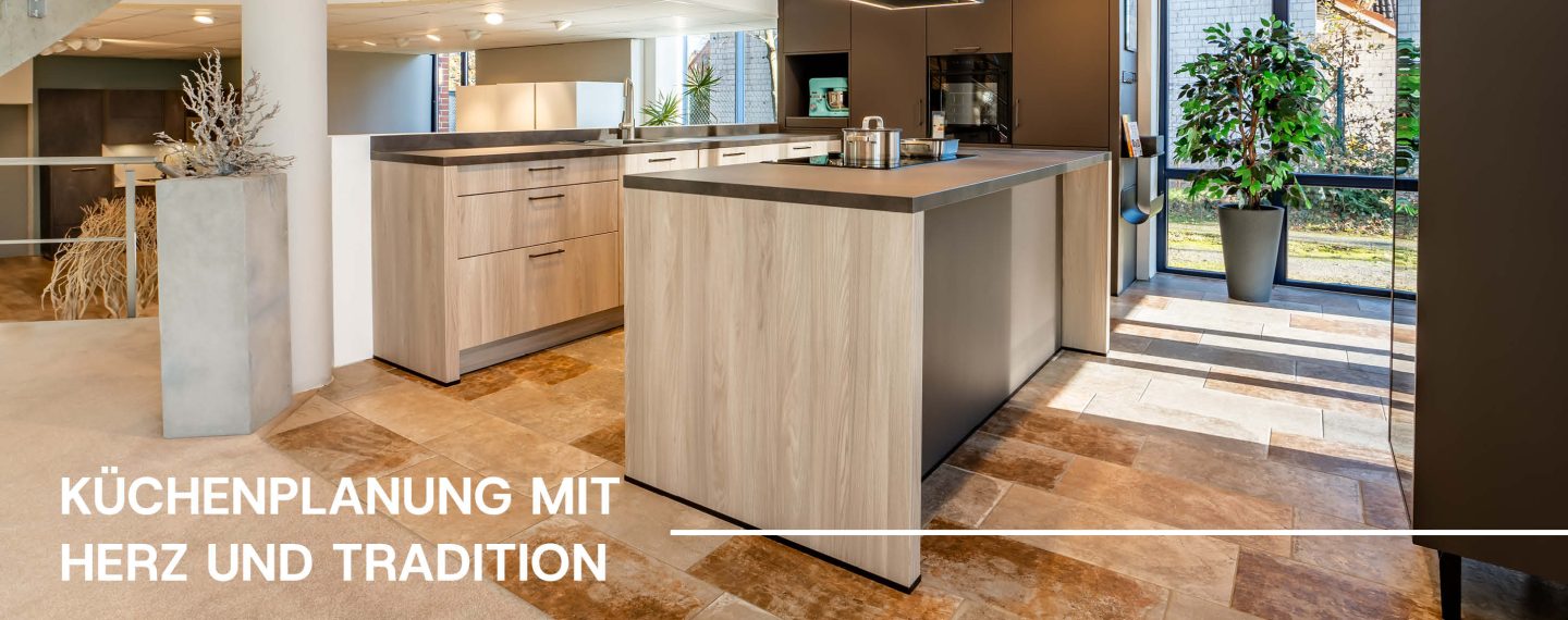 U-Küche in grau mit grauer Holzarbeitsplatte in der Ausstellun von Küchenstudio Helmke. Darauf steht 