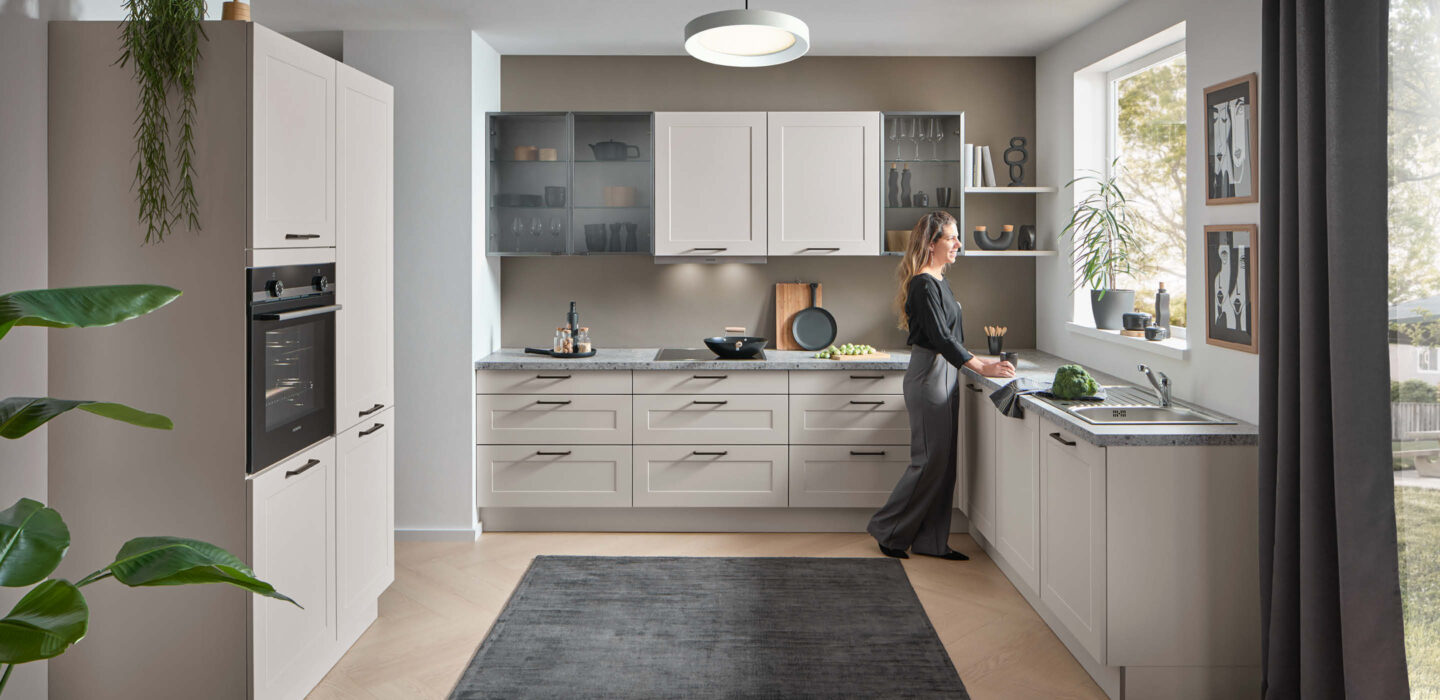 Helle Küche mit grauen Fronten und großzügiger Arbeitsfläche – klassisches Design trifft auf moderne Linienführung.