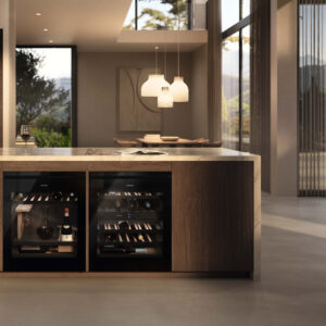 Miele Weinkühlschrank unter Arbeitsplatte mit Glastür, gelagerten Weinflaschen und Holzregalen in eleganter Küche mit Natursteinoberfläche