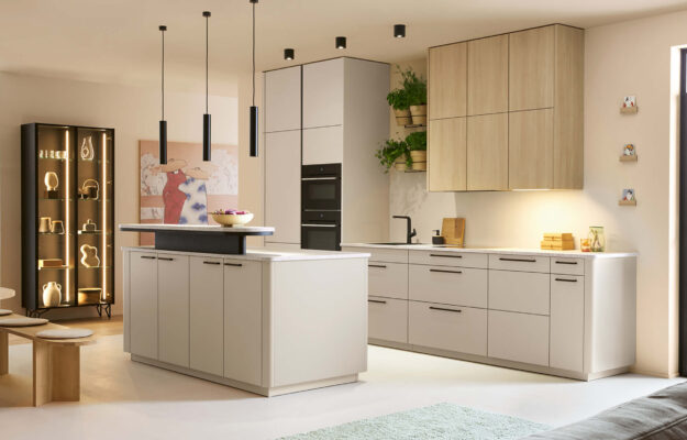 Minimalistische Schüller Küche mit heller Kücheninsel, Holz-Hängeschränken, matten Fronten, integrierten Einbaugeräten und schwarzer Armatur im modernen Wohnraum