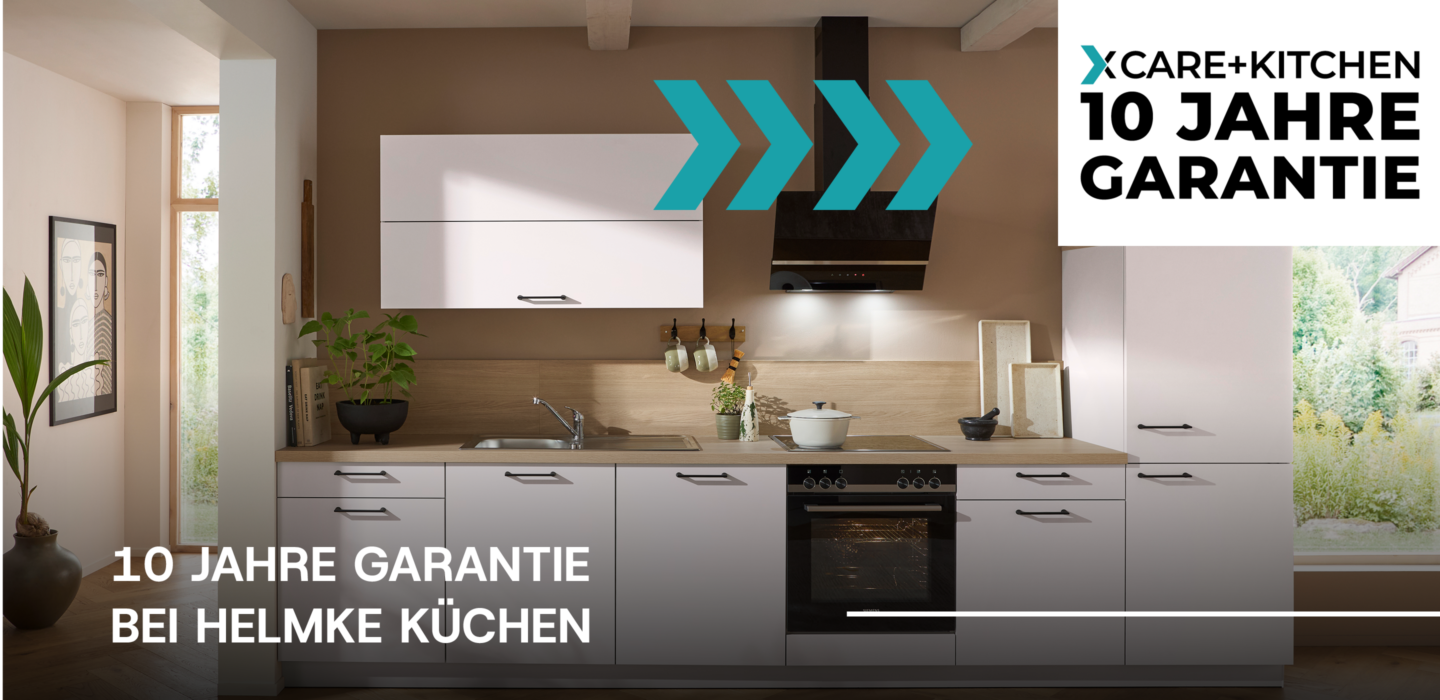 Moderne Küche von Helmke Küchen mit weißen Fronten, Holzarbeitsplatte, Einbaugeräten und Hinweis auf 10 Jahre Garantie durch Care+Kitchen.