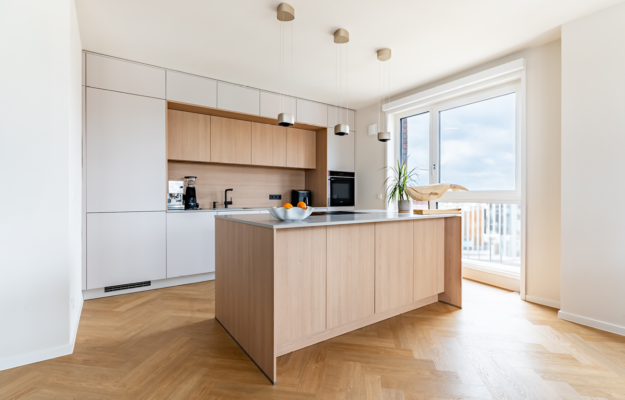 Helle Fronten, warmes Holz und eine großzügige Kochinsel schaffen eine moderne Küche mit wohnlicher Atmosphäre