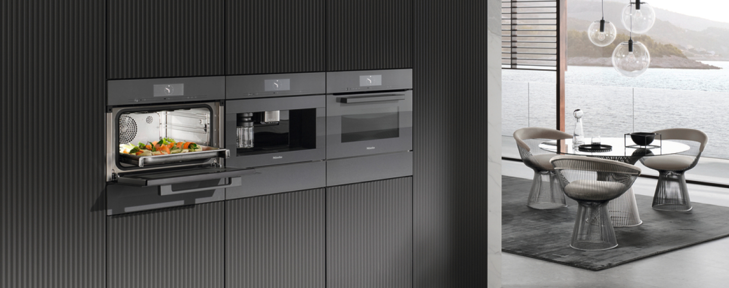 Moderne Küche mit dunklen Fronten, Miele-Einbaugeräten und integriertem Kaffeevollautomaten.
